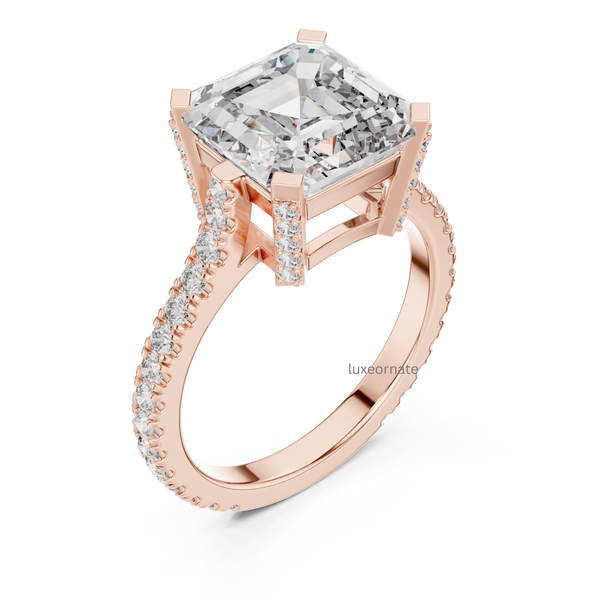 Angled rose gold emerald cut diamond engagement ring with pavé band and cathedral gallery, rectangular lab grown diamond, luxury bridal jewelry.