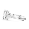 Side profile white gold emerald cut three stone diamond ring with trapezoid side diamonds, elegant bridal engagement jewelry.
