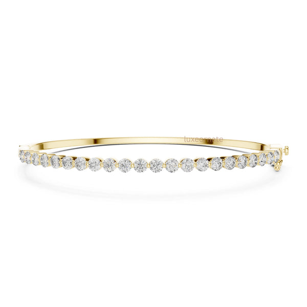Minimalist round diamond bangle bracelet in yellow gold with elegant prong set diamonds