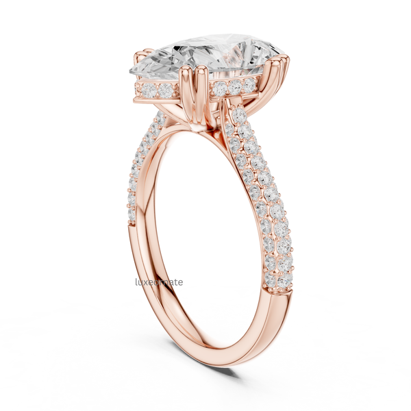 Rose gold pear cut diamond engagement ring angled view with pavé band and secure claw setting.