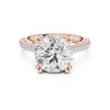 Rose gold round diamond solitaire engagement ring with double pavé band and secure claw prongs.