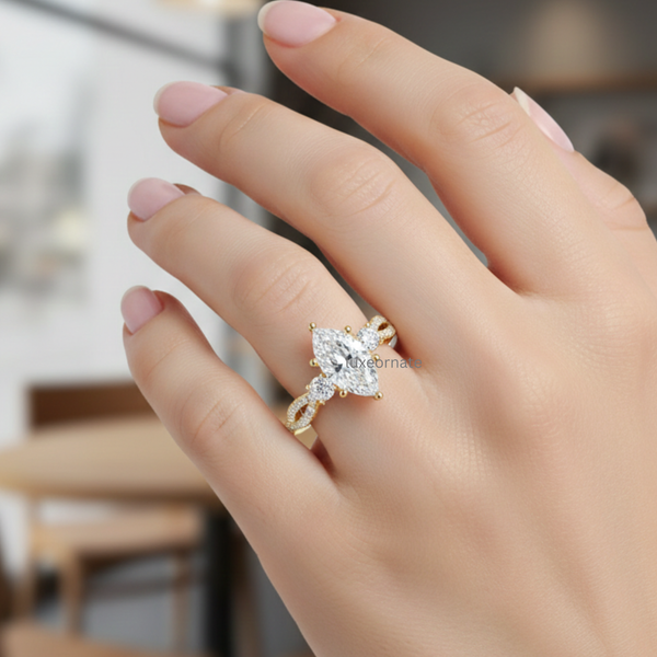 Marquise cut diamond ring on hand with round side stones and yellow gold twisted pavé band.