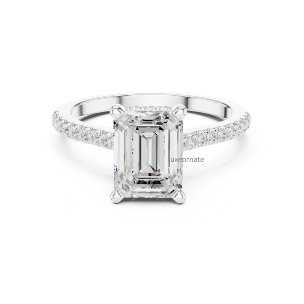 White gold emerald cut diamond ring featuring pavé-set band and four prong setting, front view