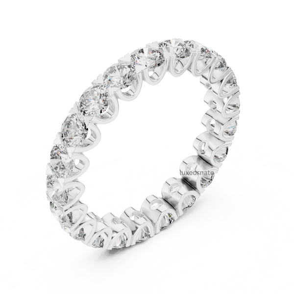 Angled white gold round brilliant diamond eternity band with shared prong full setting, modern bridal jewelry.