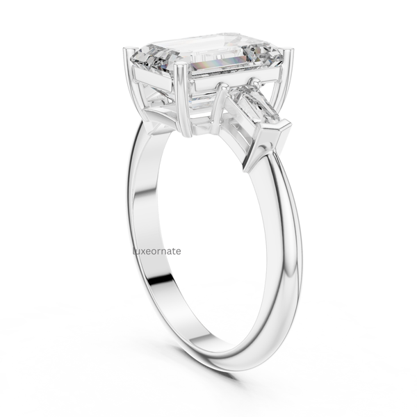 Angled white gold emerald cut diamond ring with trapezoid side stones, three stone lab grown engagement ring, luxury statement jewelry.