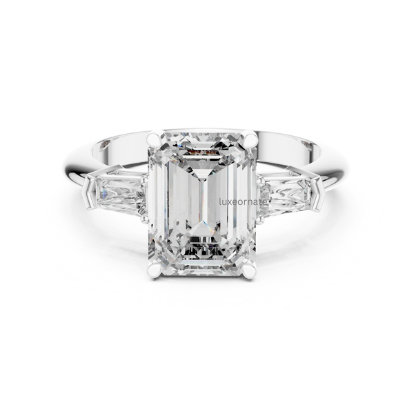 White gold emerald cut diamond engagement ring with trapezoid side diamonds, three stone lab grown bridal ring, modern fine jewelry.